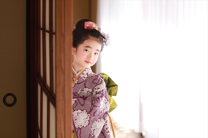 障子からこちらを見る着物の女の子